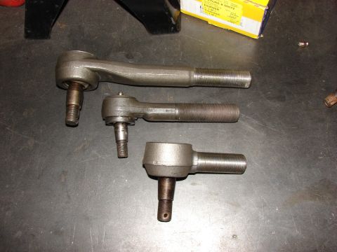 1993 Jeep Wrangler - Three tie rod ends are laid out on a workbench, with a parts box in the background.