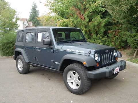 2005 Jeep Wrangler - This dark blue Jeep Wrangler Rubicon is shown from a 3/4 front angle, its distinctive grille and Rubicon badging.