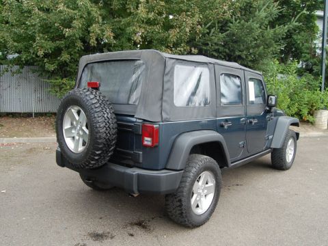 2005 Jeep Wrangler - This Jeep Wrangler features a rear-mounted spare tire and a dark blue exterior with a soft top.