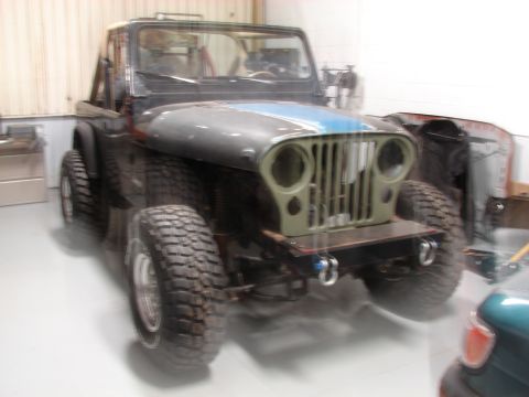 1993 Jeep Wrangler - This 1993 Jeep YJ is shown from a three-quarter front view, distinctive blue stripes on its hood.