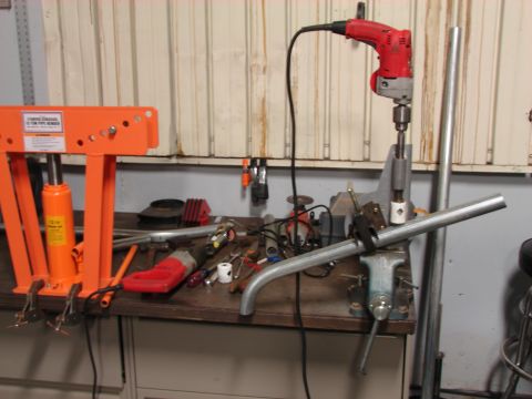 1993 Jeep Wrangler - A collection of tools and equipment are set up on a workbench for pipe fabrication.