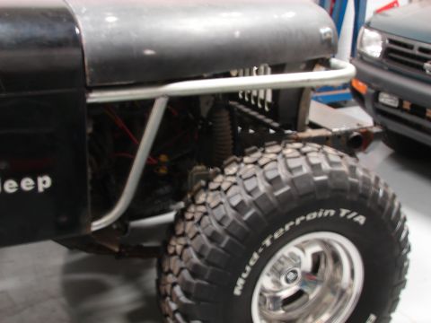 1993 Jeep Wrangler - A black Jeep is shown from the front, equipped with large Mud-Terrain T/A tires.