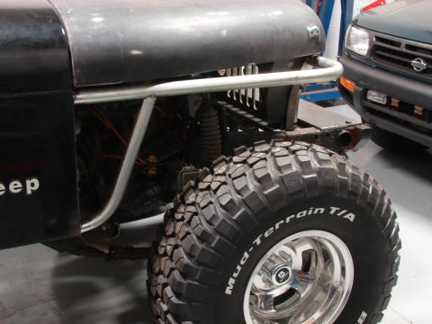 1993 Jeep Wrangler - Close-up of a Jeep's front fender and off-road tire, with another vehicle visible behind it.