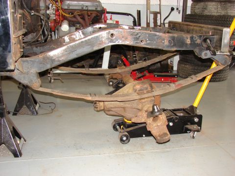 1993 Jeep Wrangler - Vehicle frame and suspension components are supported by jack stands and a floor jack.