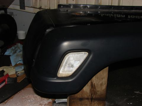 1993 Jeep Wrangler - The front fender and bumper assembly of a black Jeep YJ, a clear turn signal indicator.