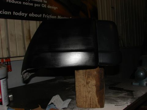 1993 Jeep Wrangler - A black plastic automotive part is shown, likely a component for a vehicle, resting on a wooden support.