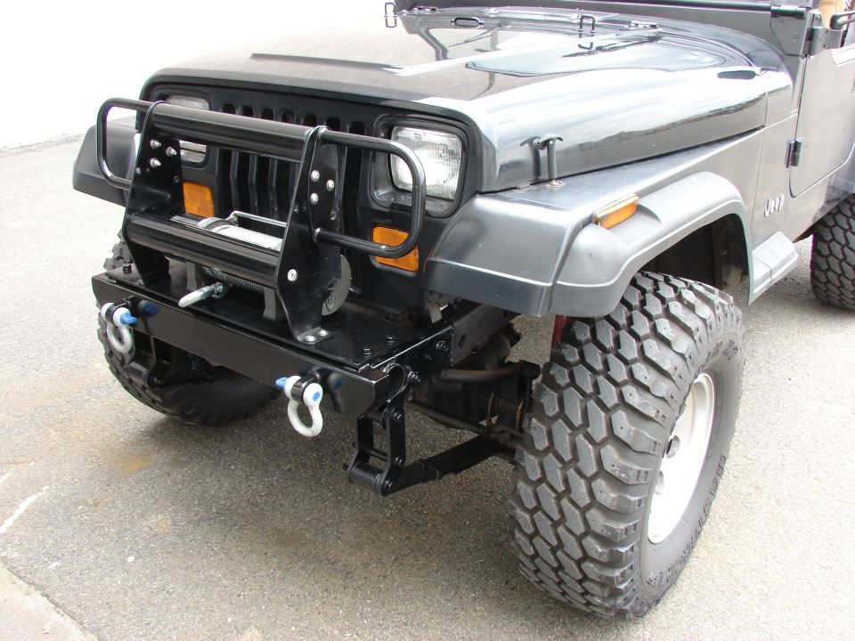 Black Jeep with winch and brush guard, front 3/4 view, off-road tires