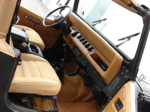 1993 Jeep Wrangler - The interior of a 1993 Jeep YJ features tan seats and dashboard with a manual transmission shifter.
