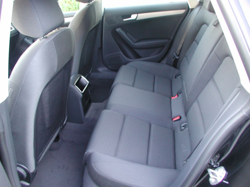 Rear seats of a 2010 Audi A4, showing fabric upholstery and seatbelts