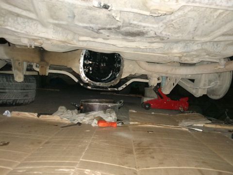 1998 Ford Crown Victoria - Vehicle's rear differential is open for service, with a floor jack in place.