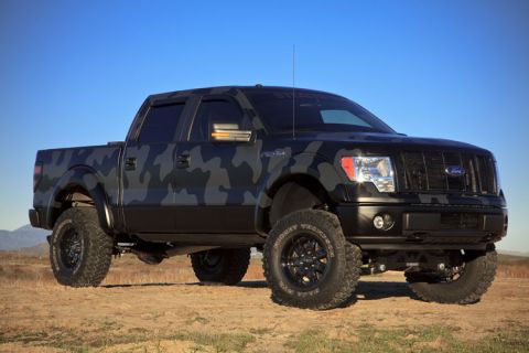1981 Ford Bronco - Lifted Ford F-150 pickup truck with a custom camouflage wrap and off-road tires.