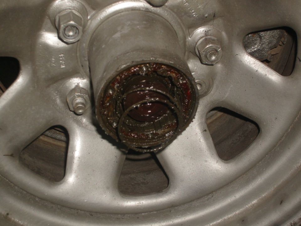 Close-up of a greasy wheel hub with a spring inside