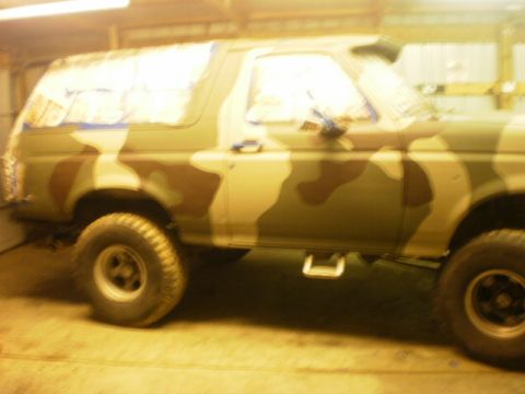 1995 Ford Bronco - This Ford Bronco, painted in camouflage, is viewed from the side in what appears to be a garage.