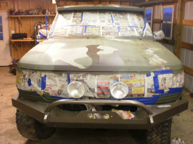 Ford Bronco freshly painted in camouflage with newspaper masking still taped on