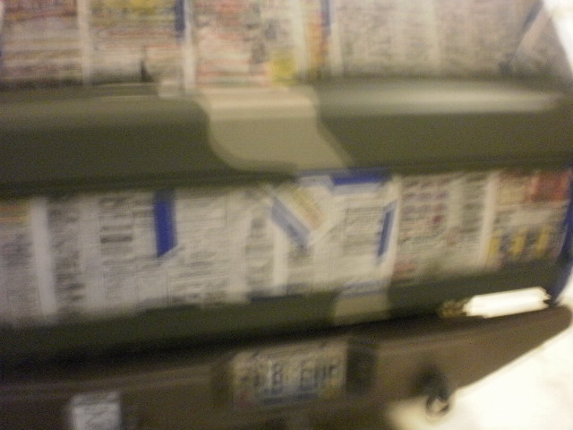 Blurry rear of camo-painted SUV with newspaper-masked rear windows