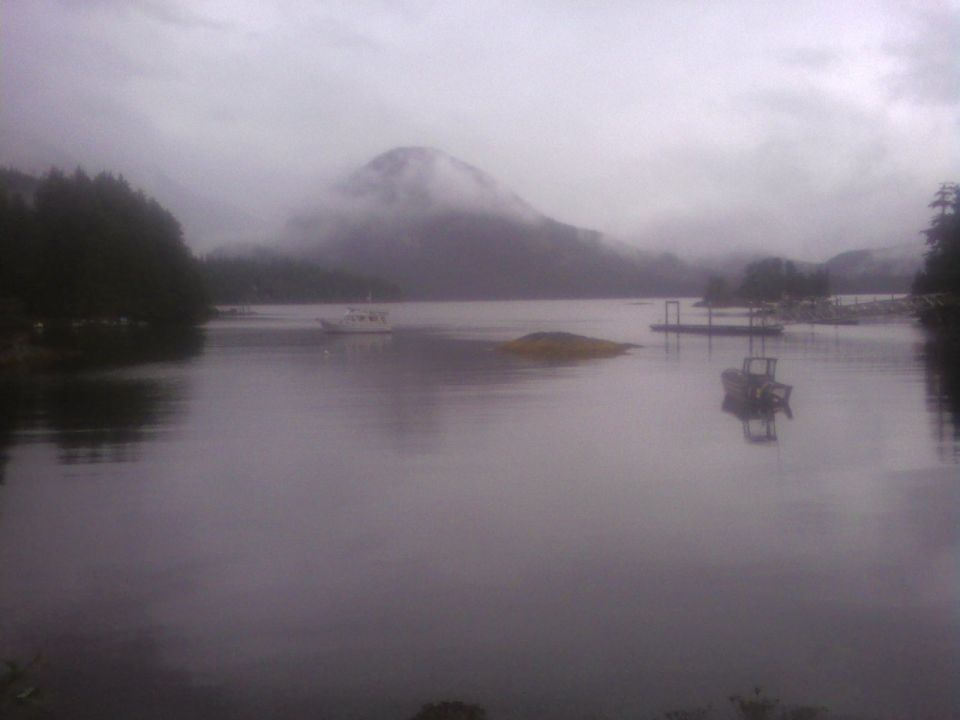 Boats on a misty lake with mountains