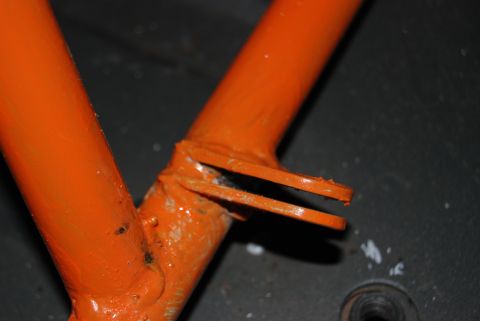 1982 Ford Bronco - Close-up of an orange painted metal frame part with a Supermotors.net watermark.