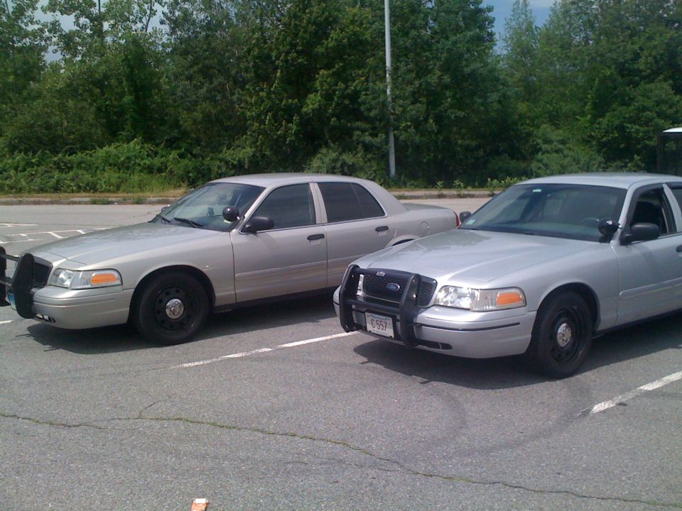 Two silver 2009 Ford Crown Victorias with push bars parked side-by-side