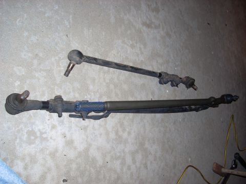 1989 Ford Bronco - Steering linkage components shown on a concrete surface.