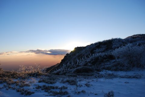 1996 Ford Bronco - A winter mountain scene at sunrise with frost-covered plants and a clear blue sky above the clouds.