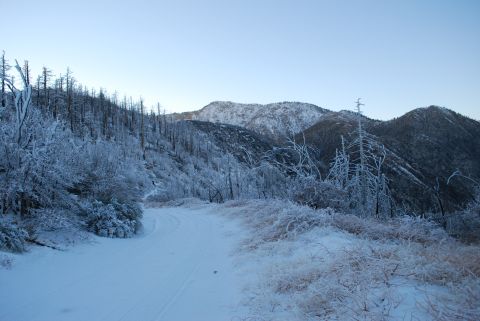 1996 Ford Bronco - A remote mountain road is covered in snow and frost under a clear sky.