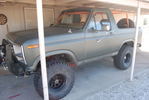 1982 Ford Bronco - This Ford Bronco, modified with an orange roll cage, is seen from a three-quarter front view.