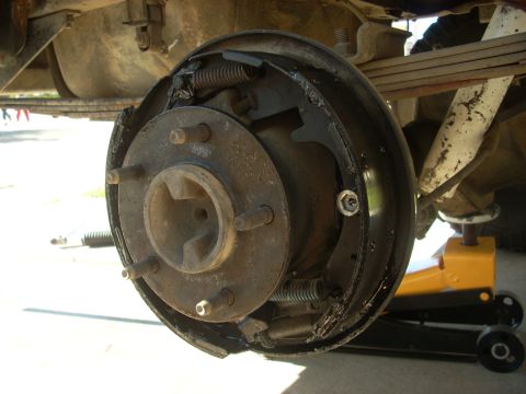 1989 Ford Bronco - Close-up of a vehicle's rear drum brake assembly, showing wear and tear.