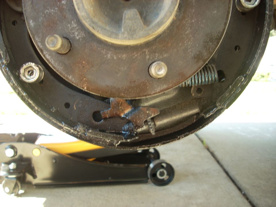 Worn brake drum and shoes with a jack underneath