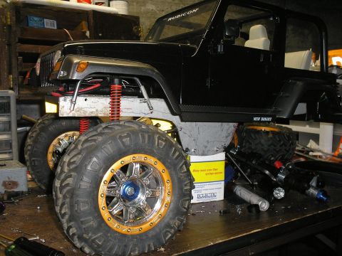 1994 Ford Escort - A heavily modified Jeep Wrangler sits on a workbench surrounded by tools and parts, suggesting ongoing customization.