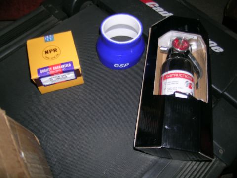 1995 Ford Probe - Automotive parts including a coupler and a fire extinguisher are laid out on a dark surface.