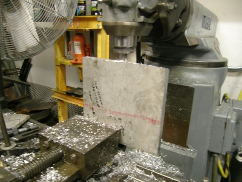 1995 Ford Probe - A metal block is being machined on a milling machine, with handwritten measurements visible on the block's surface.