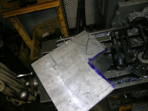 1995 Ford Probe - A metal plate is being prepared for cutting on a drill press, with markings indicating the desired shape.