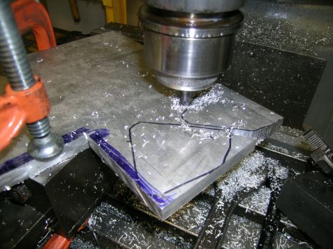 1995 Ford Probe - A milling machine is used to cut a custom metal part, with shavings accumulating around the workpiece.