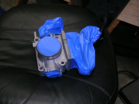 1993 Ford Probe - A throttle body is covered with blue tape, likely for protection during a repair or cleaning process.