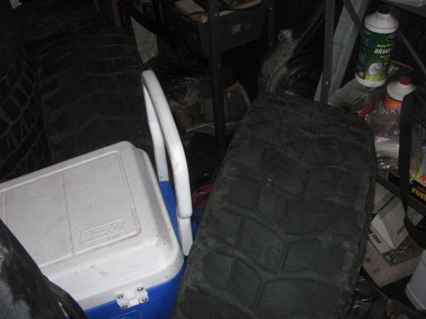 1968 Ford Mustang - A collection of tires and a cooler are visible in a storage area with various items on shelves.