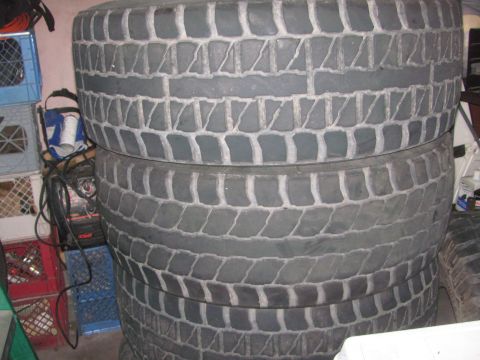 1968 Ford Mustang - Several large tires are stacked on top of each other in what appears to be a storage area.