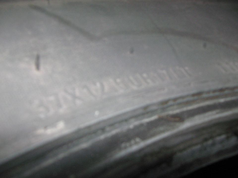 Tire sidewall with embossed text, partially obscured