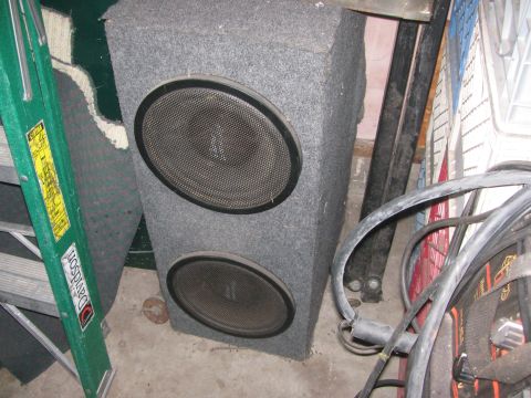 1968 Ford Mustang - A dual subwoofer speaker box is visible in a cluttered area with a ladder and electrical cables.
