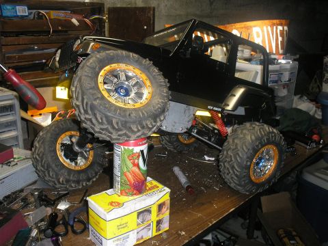 1994 Ford Escort - A black remote control rock crawler vehicle is displayed on a workbench amidst tools and supplies.