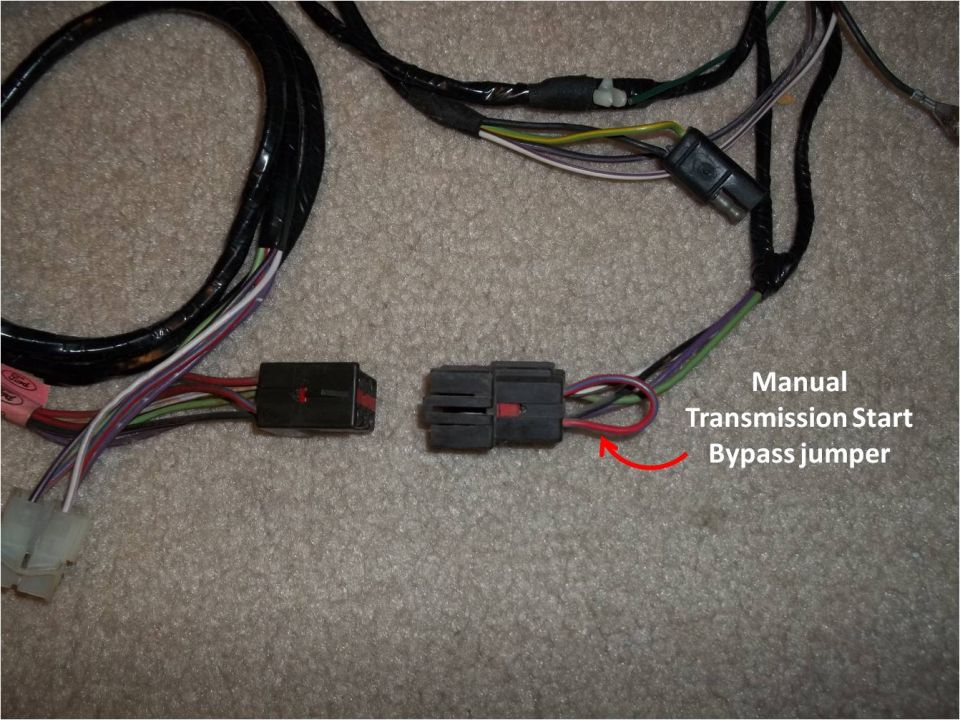 Two wiring harness connectors on carpet labeled Manual Transmission Start Bypass jumper