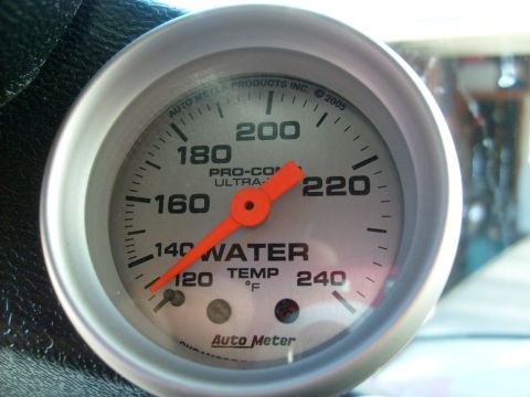 1986 Ford Bronco - Close-up of an Auto Meter water temperature gauge with an orange needle.