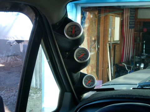1986 Ford Bronco - Three gauges are mounted on the A-pillar inside a vehicle, with a Supermotors logo on the dash.