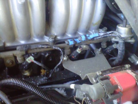 1994 Ford F-150 - This image shows a close-up view of the fuel injectors and fuel rail assembly within a vehicle's engine compartment.