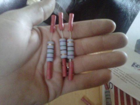1994 Ford F-150 - A hand holds three electronic resistors, each with red ends and white bodies marked with colored bands.