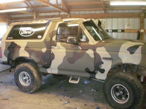 1995 Ford Bronco - This 1995 Ford Bronco is covered in a camouflage wrap and parked inside a garage.