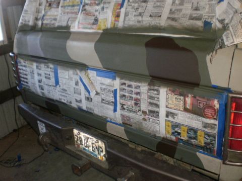 1995 Ford Bronco - A vehicle's rear is covered in newspaper and tape, preparing for a camouflage paint job.