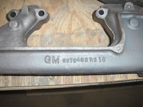 1970 Chevrolet Camaro - A cast iron exhaust manifold with GM part numbers is shown close-up.