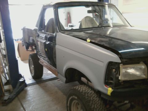 1994 Ford Bronco - This truck appears to be undergoing bodywork, with primer applied to the fender and the hood open.