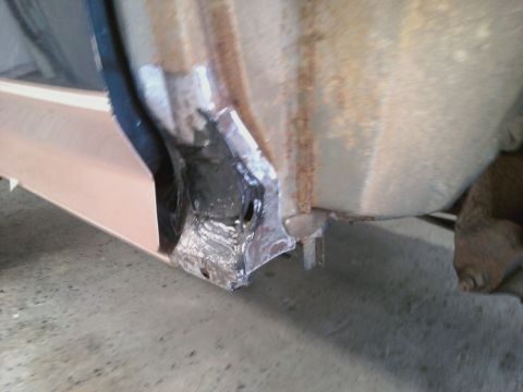 1994 Ford Bronco - Close-up of a vehicle's rocker panel undergoing repair, revealing rust and welding.