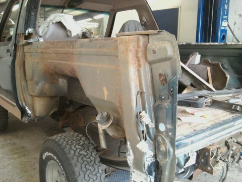 1994 Ford Bronco - Vehicle body panels showing significant rust and damage, indicating a need for extensive repair work.